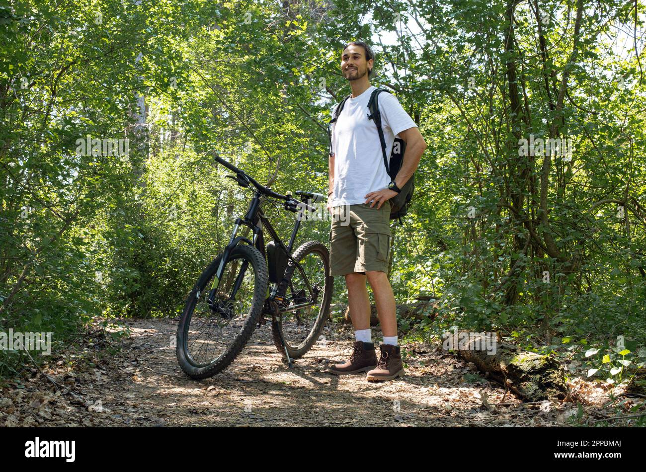 Uomo con bicicletta nella foresta Foto Stock