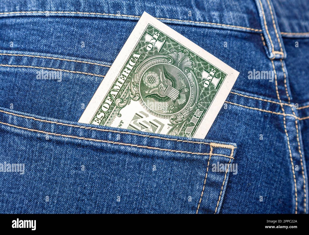 Banconota un dollaro americano che esce dalla tasca posteriore dei jeans Foto Stock