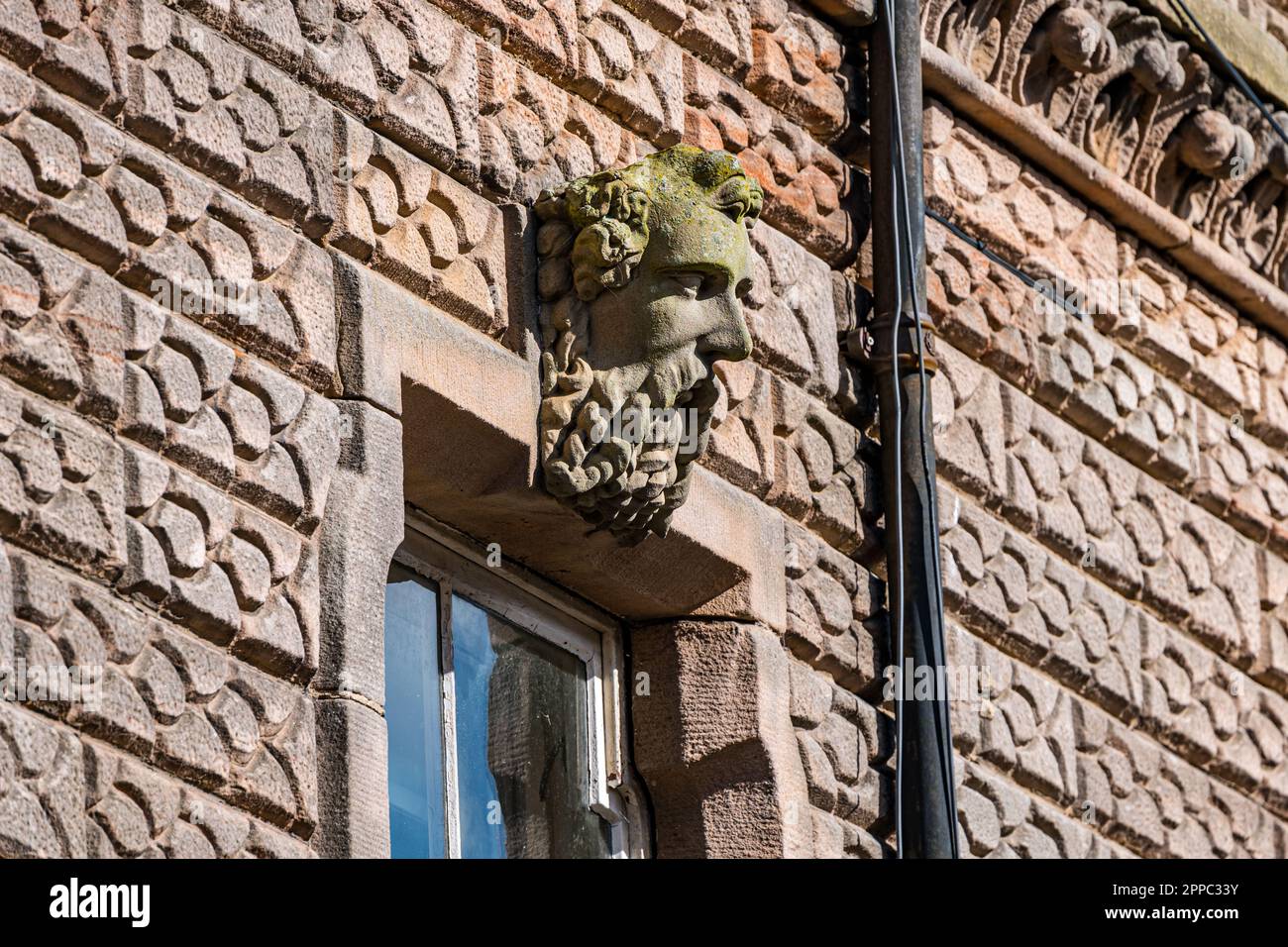 Testa scultura scolpita di un vecchio bearded sopra la finestra esterna di un vecchio edificio, Berwick Upon Tweed, Northumberland, Inghilterra, Regno Unito Foto Stock