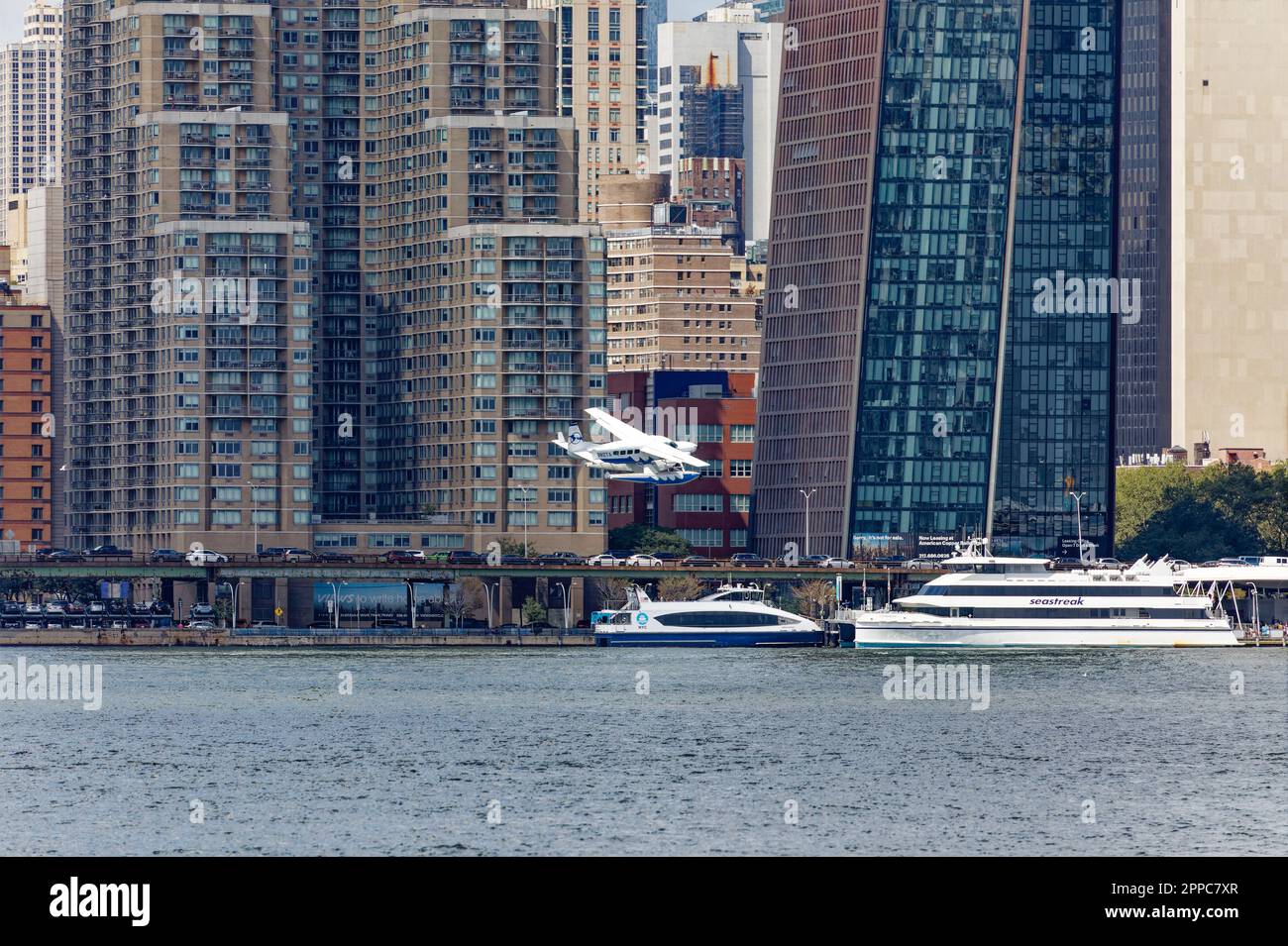 Il Tropic Oceans Airways Cessna 208B decade dalla base degli idrovolanti dello Skyports di New York sull'East River. Sfondo: Vista 34 e il rame. Foto Stock