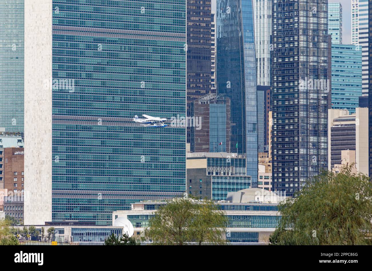 Il Tropic Oceans Airways Cessna 208B decade dalla base degli idrovolanti dello Skyports di New York sull'East River. Contesto: Edificio del Segretariato delle Nazioni Unite. Foto Stock