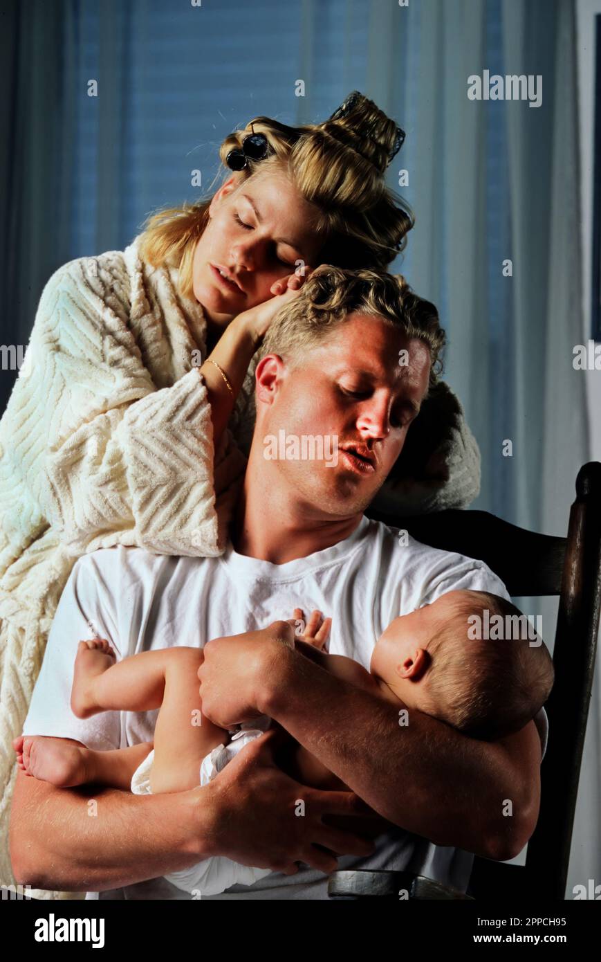 Madre e padre sfiniti e insonni con bambino neonato che piange Foto Stock
