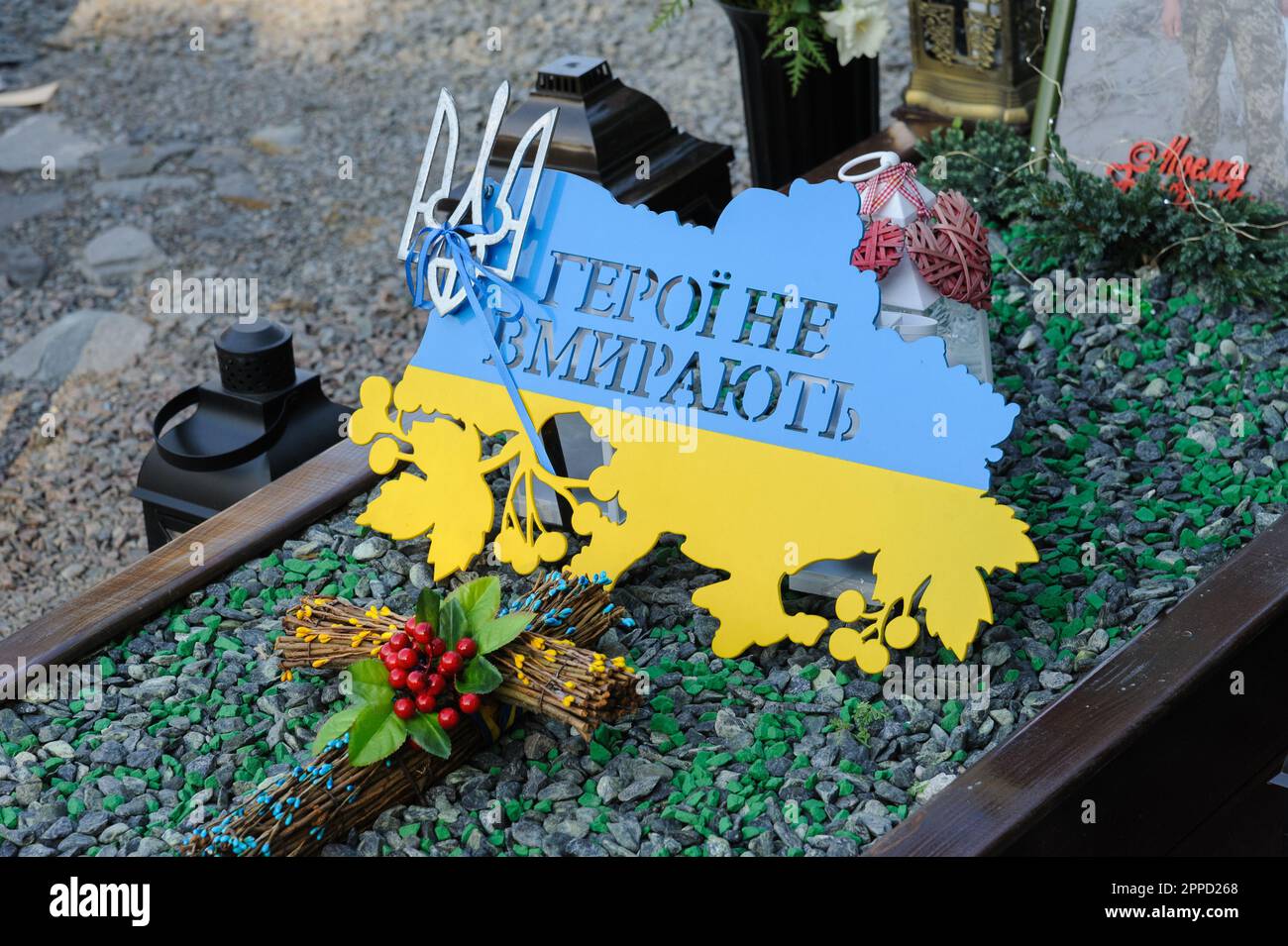 Lviv, Ucraina 23 aprile 2023. Un segno con l'iscrizione 'Eroi non morire' sotto forma di una mappa dell'Ucraina e i colori della bandiera visto sulla tomba di una tomba di un soldato caduto nel campo di Marte al cimitero di Lychakiv. Gli eroi dell'Ucraina, militari che difesero il territorio ucraino sono sepolti qui. La Russia ha invaso l'Ucraina il 24 febbraio 2022, scatenando il più grande attacco militare in Europa dalla seconda guerra mondiale Foto Stock