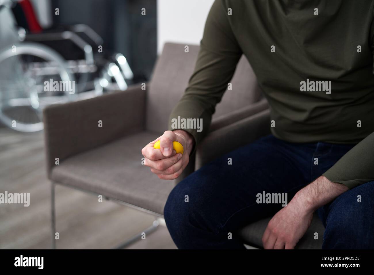 L'uomo stringe la palla stress seduto in sala d'attesa Foto Stock