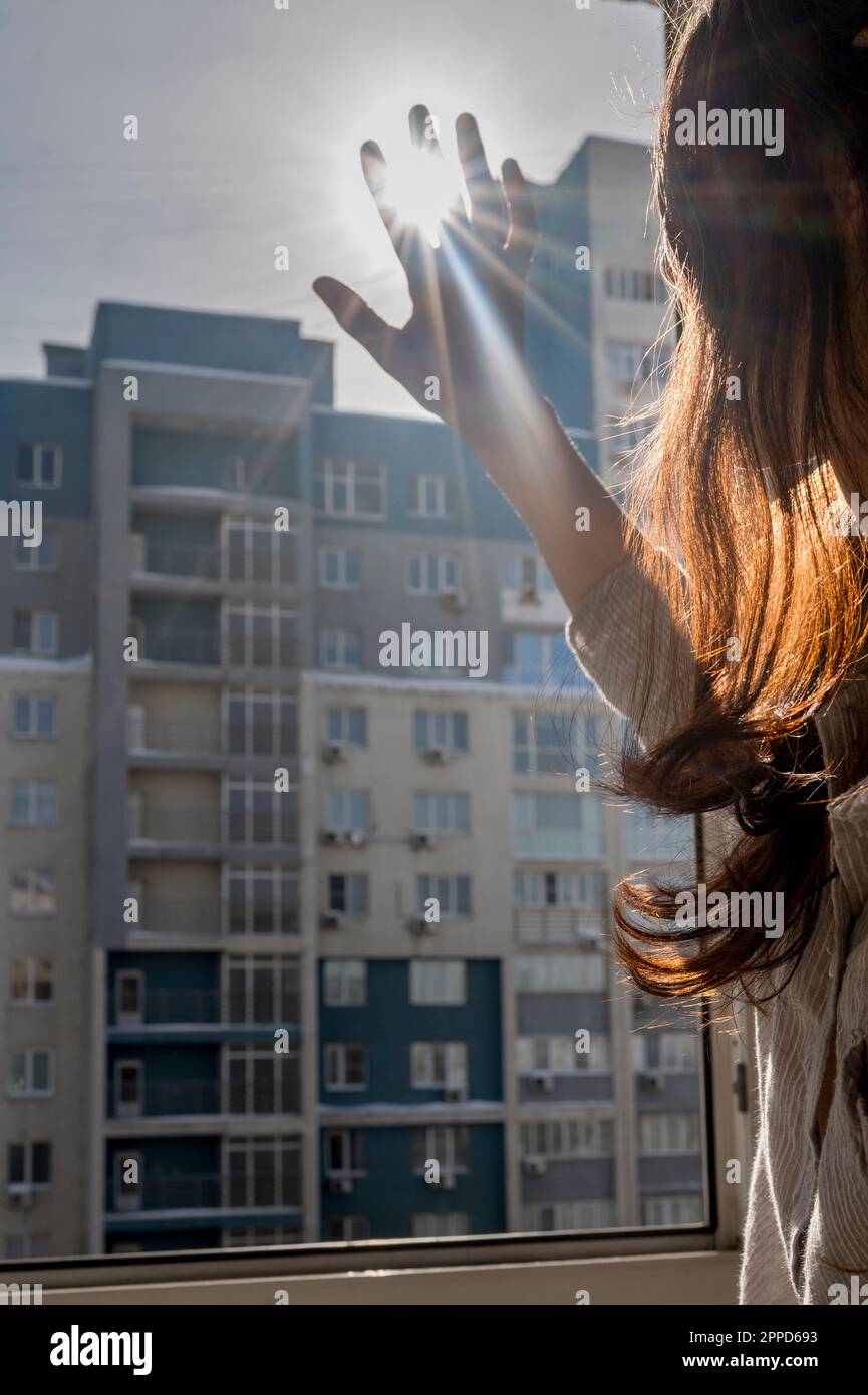 Donna che scherza gli occhi dalla finestra a casa Foto Stock