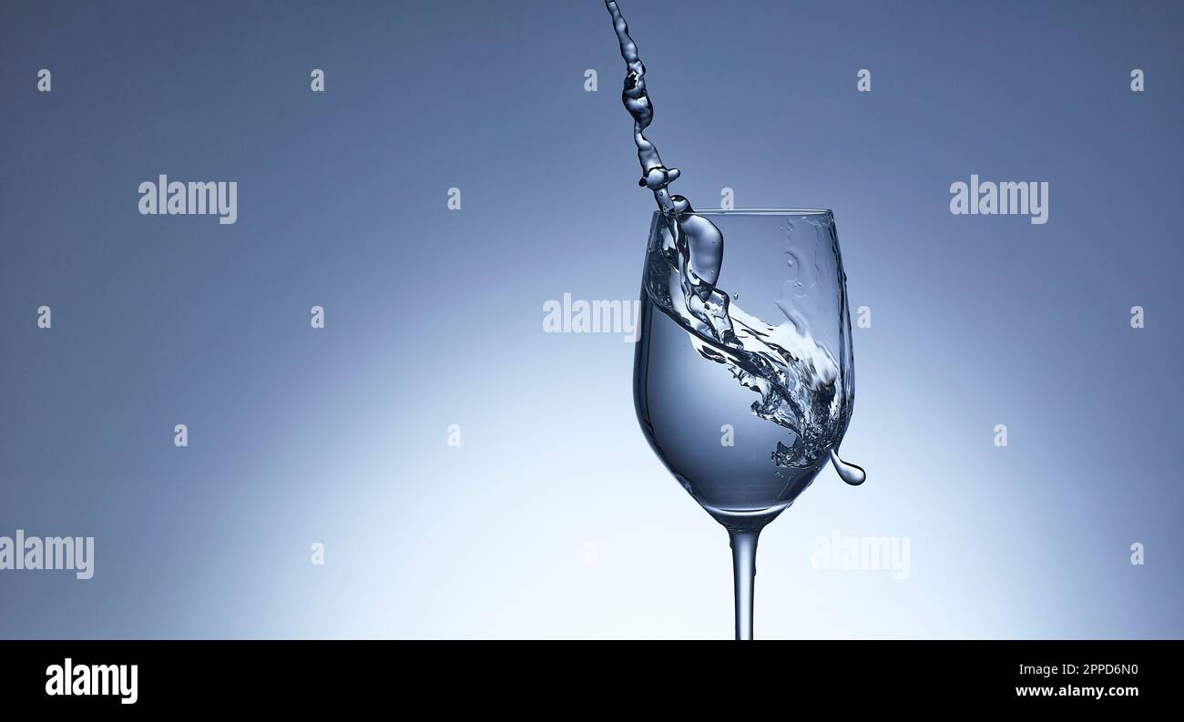 Colpo da studio di acqua limpida che si riversa nel vino Foto Stock