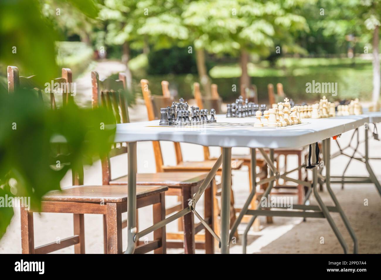Spagna, Madrid, sedie vuote di fronte ai tavoli da scacchi all'aperto nel Parco El Retiro Foto Stock