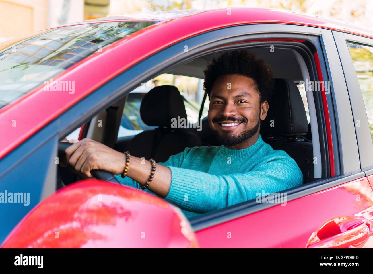 Uomo sorridente seduto in auto Foto Stock