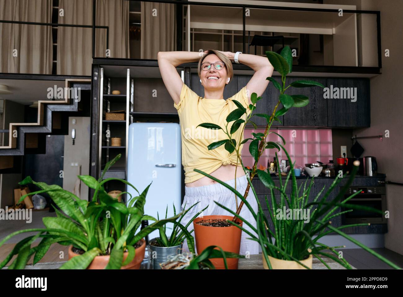 Donna spensierata con le mani sulla testa in piedi a casa Foto Stock