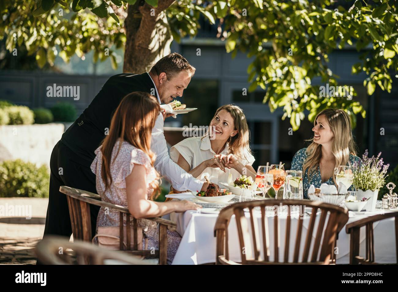 Il cameriere serve cibo alle donne al ristorante Foto Stock