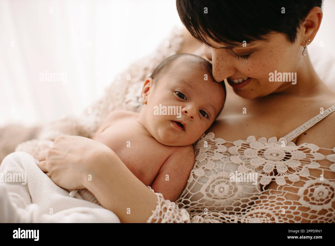 Madre che abbraccia il neonato Foto Stock