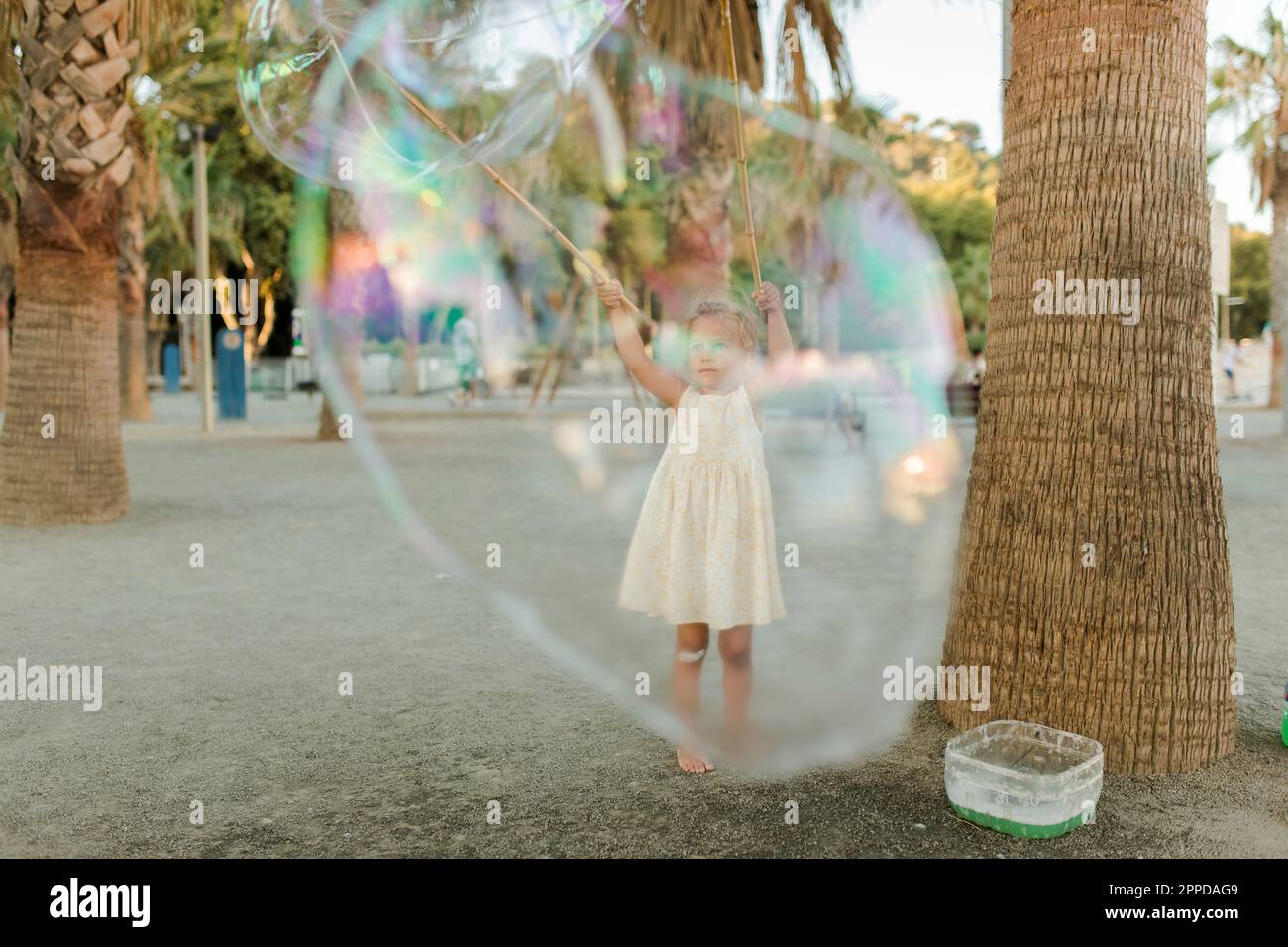 Ragazza che gioca con una grande bolla di sapone Foto Stock