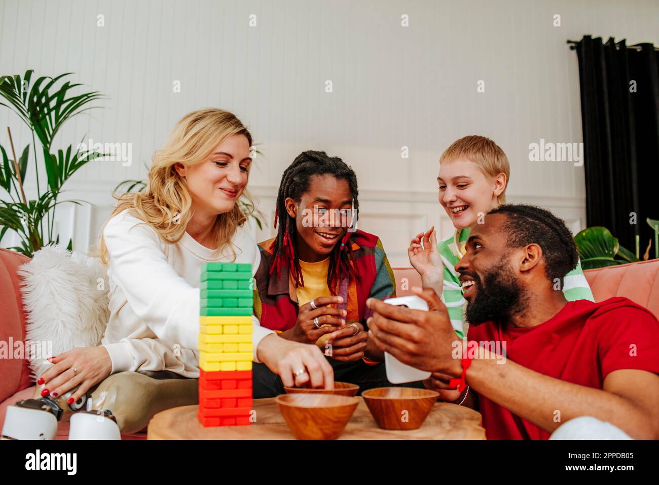 Felici amici diversi che giocano a TOY Block e trascorrono il tempo libero a casa Foto Stock