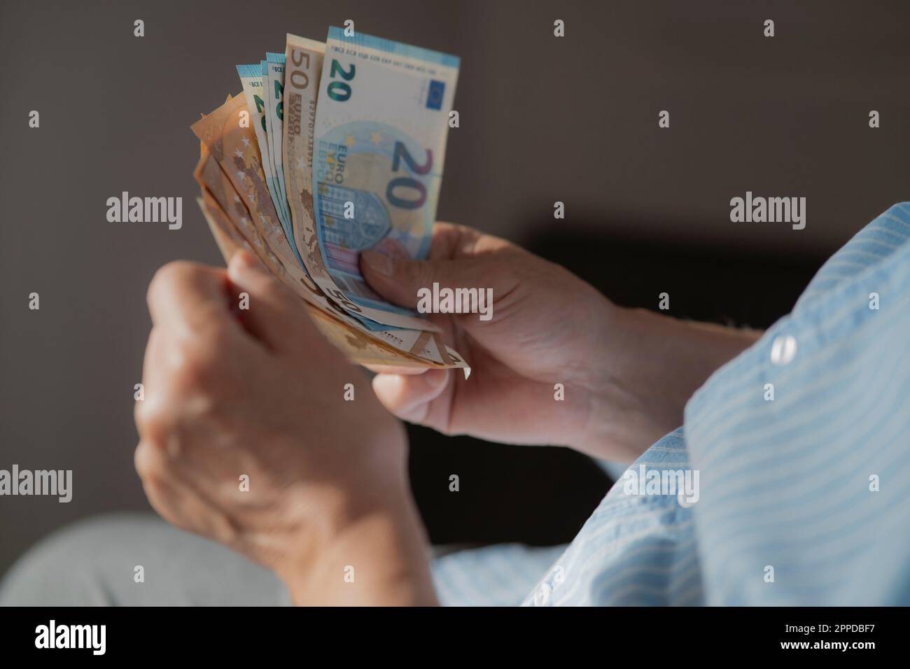 Mani di un uomo anziano che conta la valuta europea Foto Stock