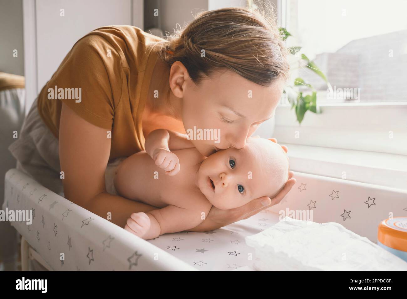 Madre che baciano il bambino a casa Foto Stock