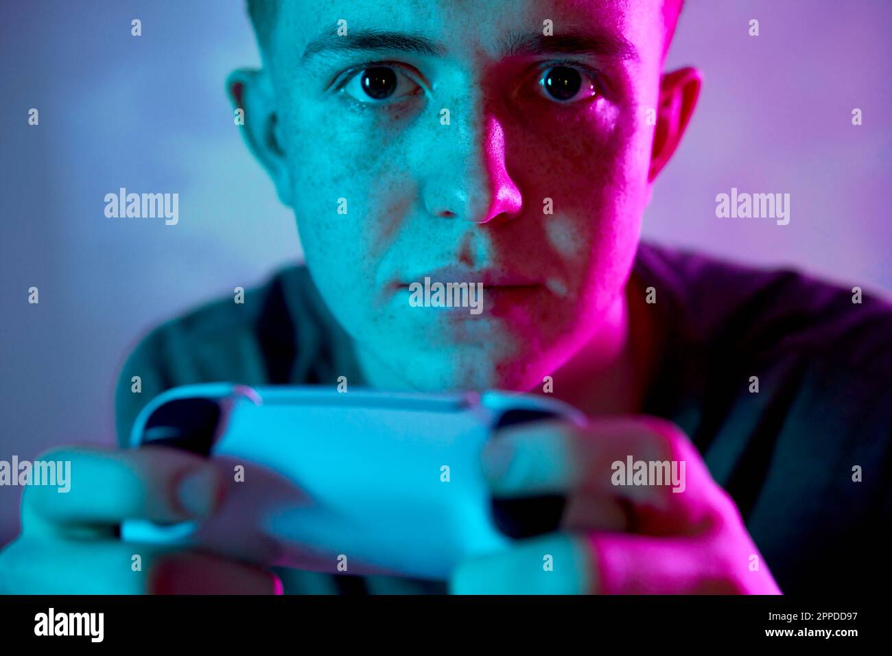Giovane uomo con controller che gioca a un videogioco Foto Stock