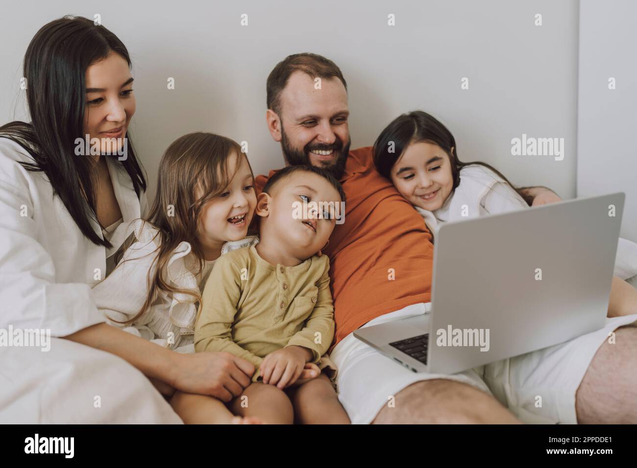 Famiglia sorridente che usa il notebook insieme a casa Foto Stock
