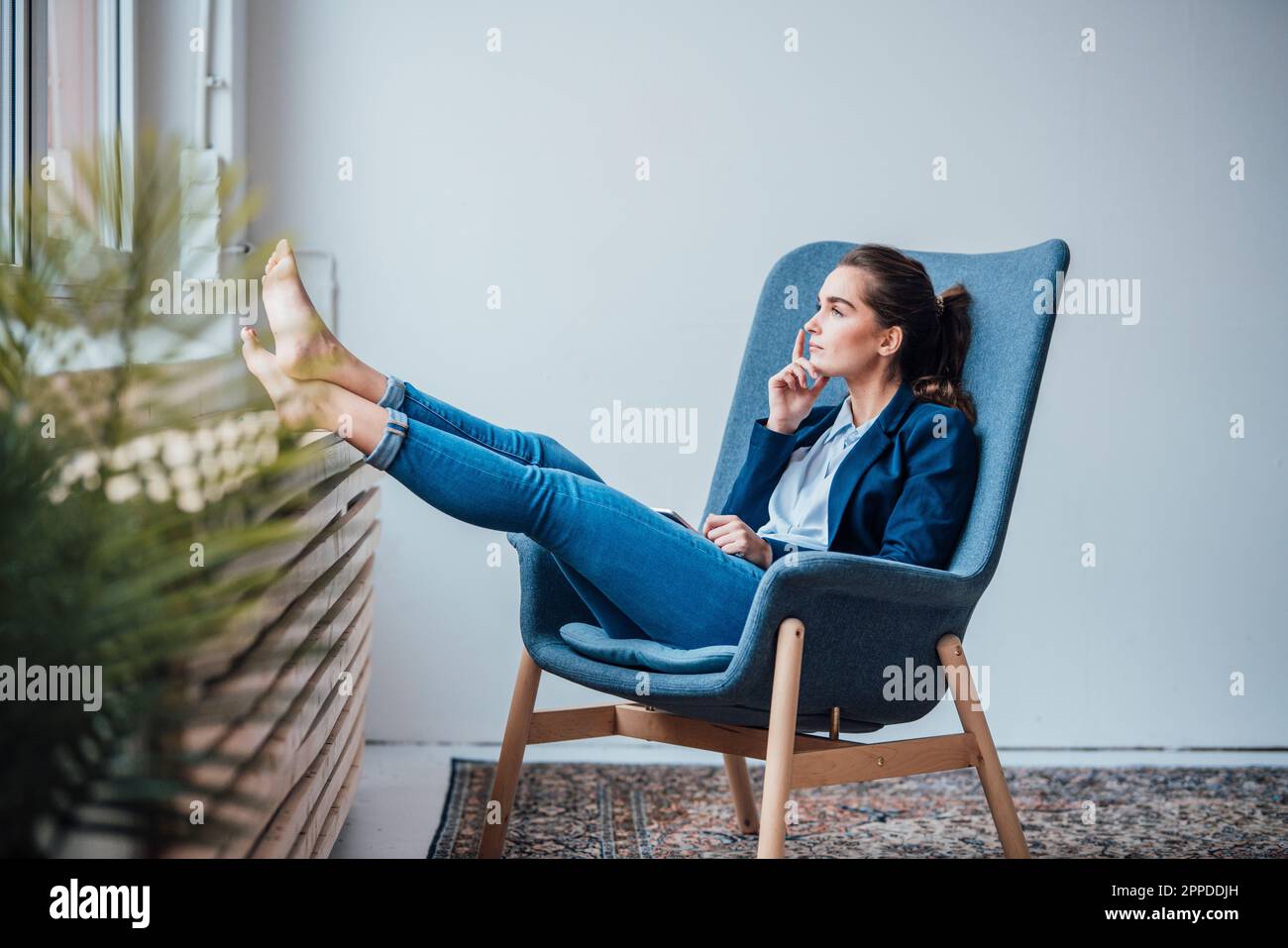Giovane donna d'affari premurosa seduta sulla poltrona Foto Stock