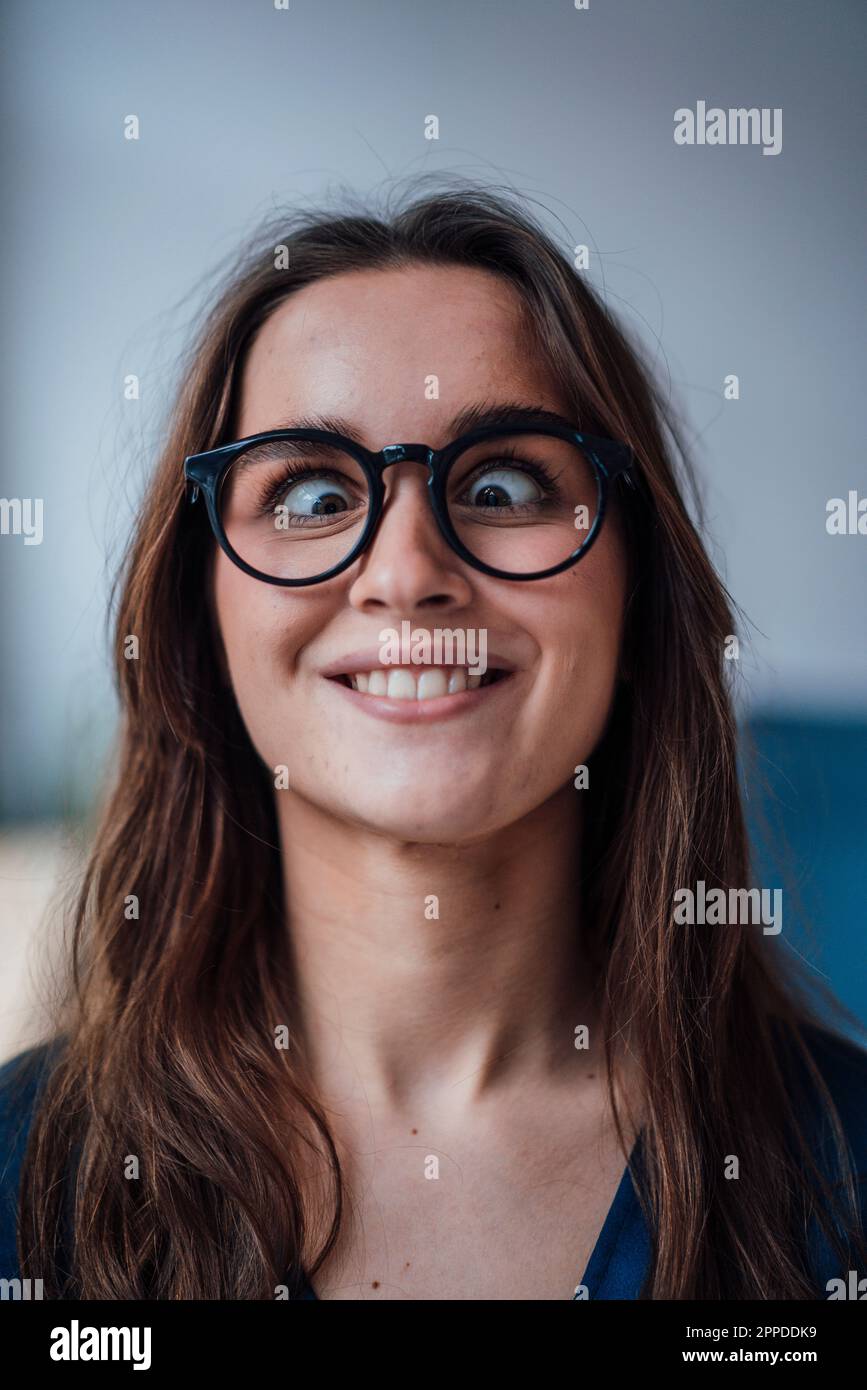 Giovane donna d'affari allegra che fa il viso divertente Foto Stock