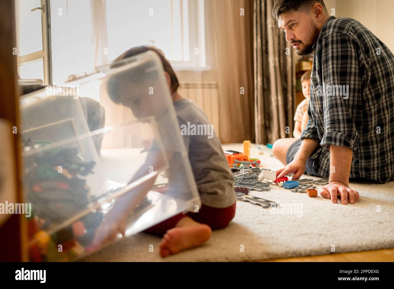 Ragazzi che giocano con il padre a casa Foto Stock