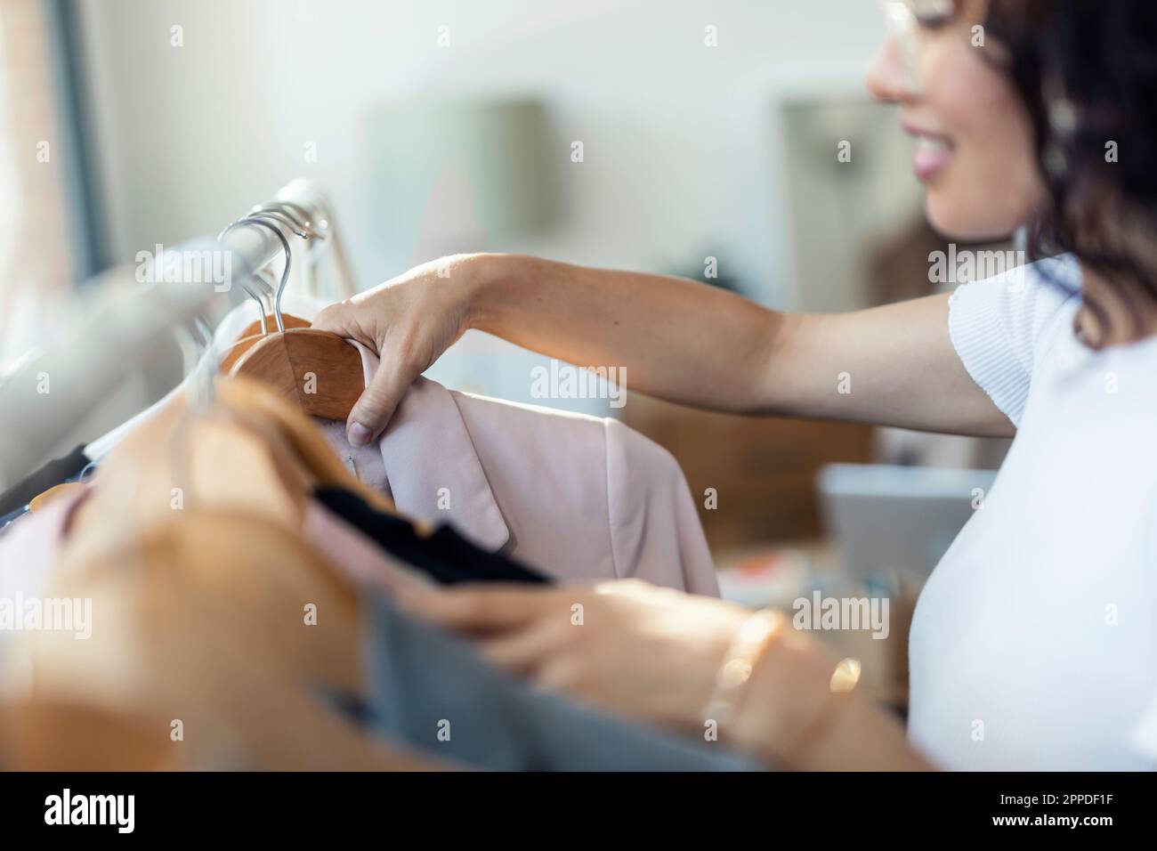 Stilista di moda che organizza i vestiti in studio Foto Stock