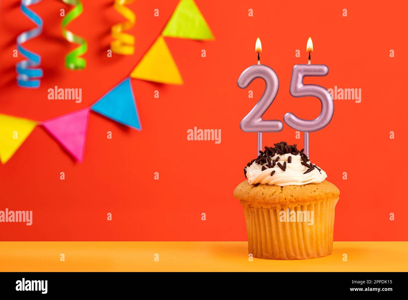 Numero 25 candela - torta di compleanno su sfondo arancione con concia Foto Stock