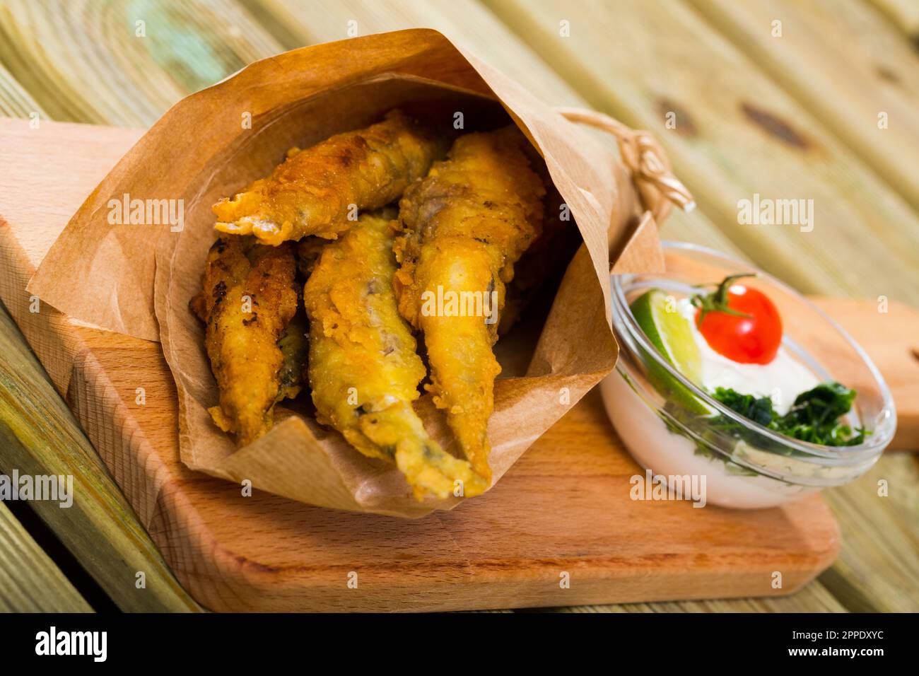 Acciughe fritte in padella con salsa cremosa al formaggio, verdure Foto Stock