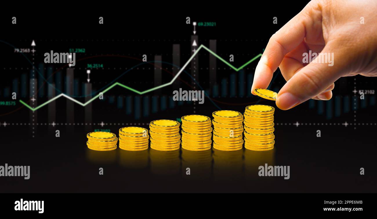 Concetto di investimento, mano che mette la moneta d'oro a pila di monete con grafico sfocato su sfondo nero Foto Stock