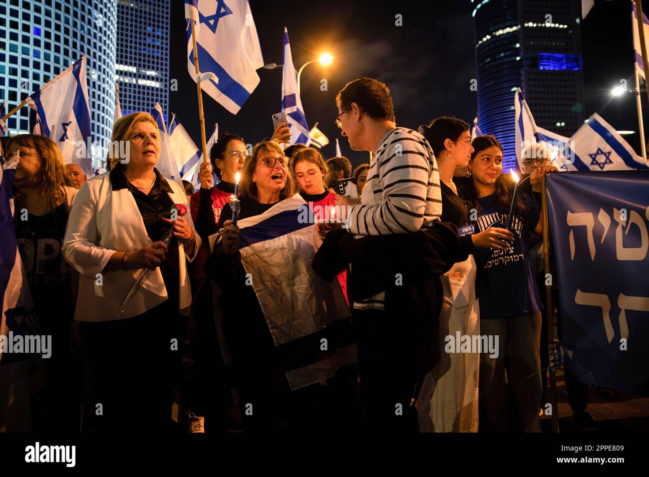 Tel Aviv, Israele. 22nd Apr, 2023. Il membro della Knesset, ORNA Barbivai, tiene una rosa accanto ai manifestanti con candele commemorative per i soldati israeliani caduti e le vittime del terrore durante una manifestazione contro la revisione giudiziaria. Credit: SOPA Images Limited/Alamy Live News Foto Stock