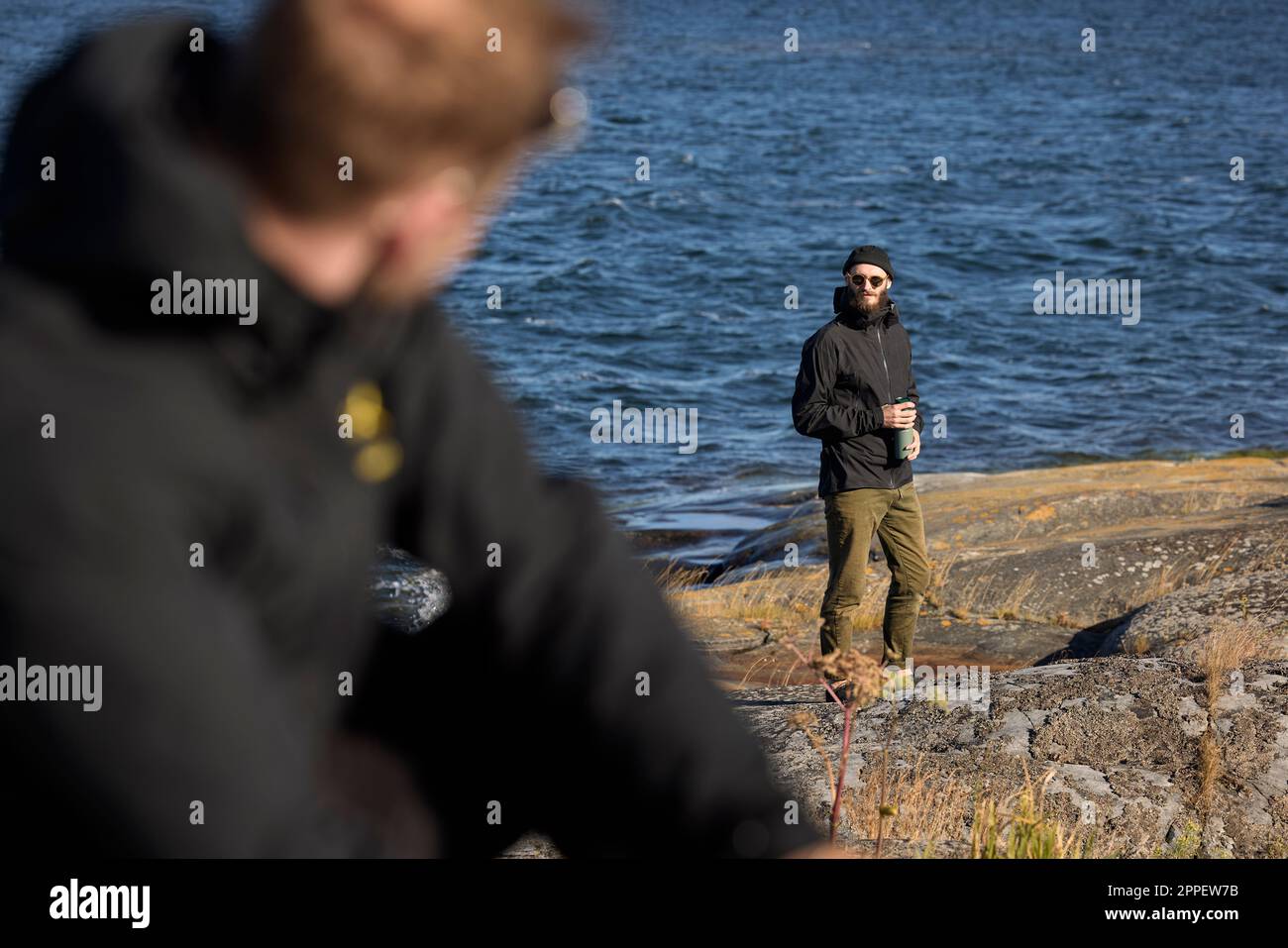 Vista di un uomo in piedi sulla costa rocciosa Foto Stock