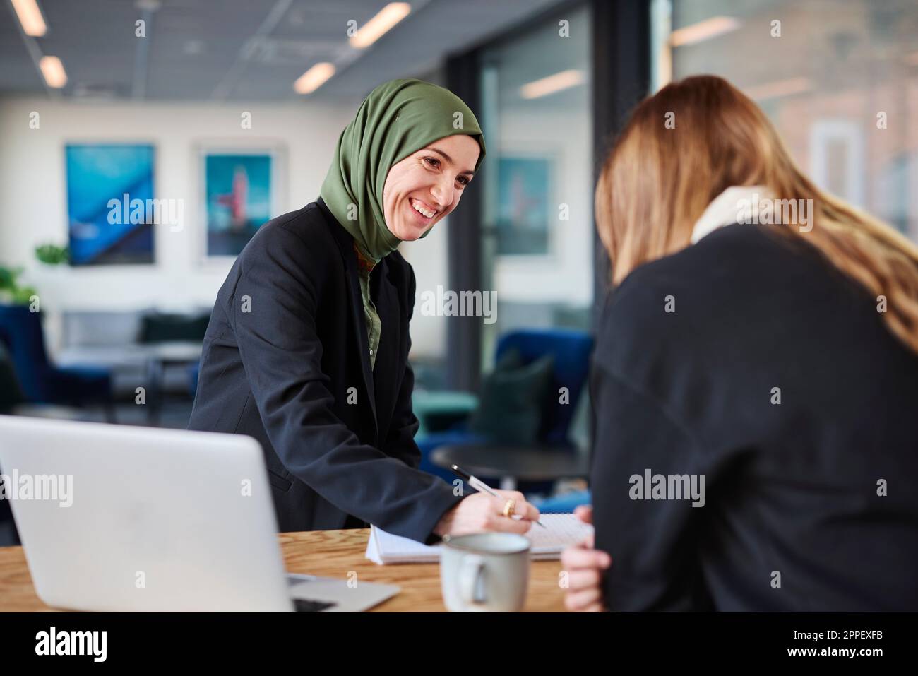 Donne che siedono insieme in ufficio Foto Stock