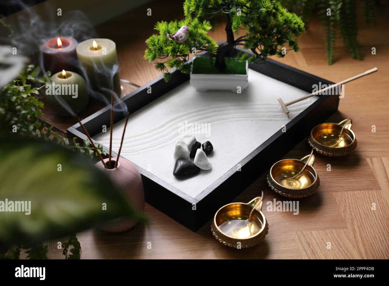 Bel giardino zen in miniatura, bastoni di incenso e lampade ad olio sul  tavolo Foto stock - Alamy
