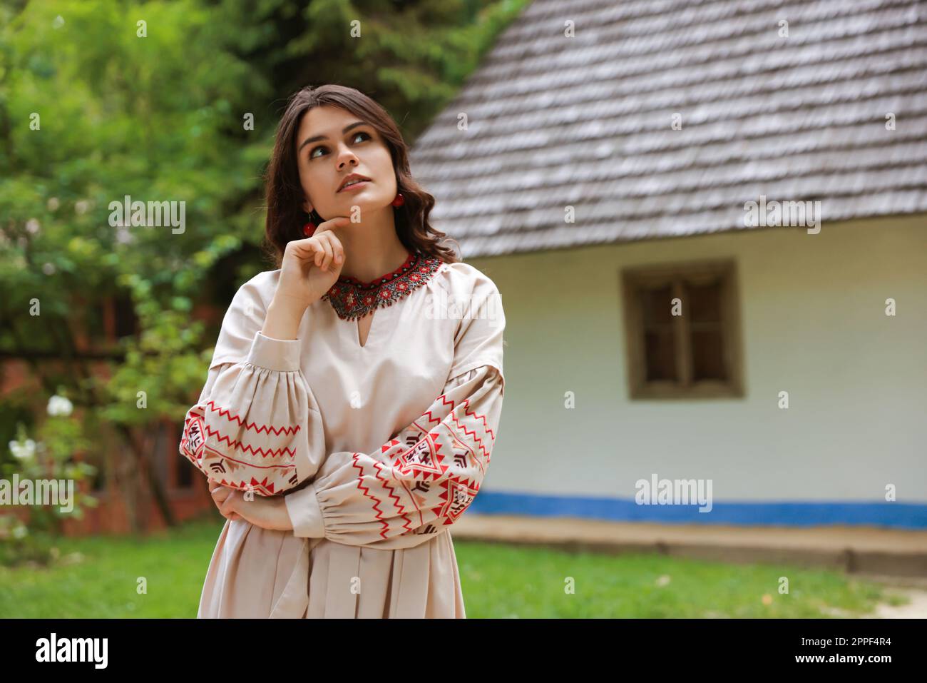 Bella donna vestito ricamato in villaggio, spazio per il testo. Vestiti nazionali ucraini Foto Stock