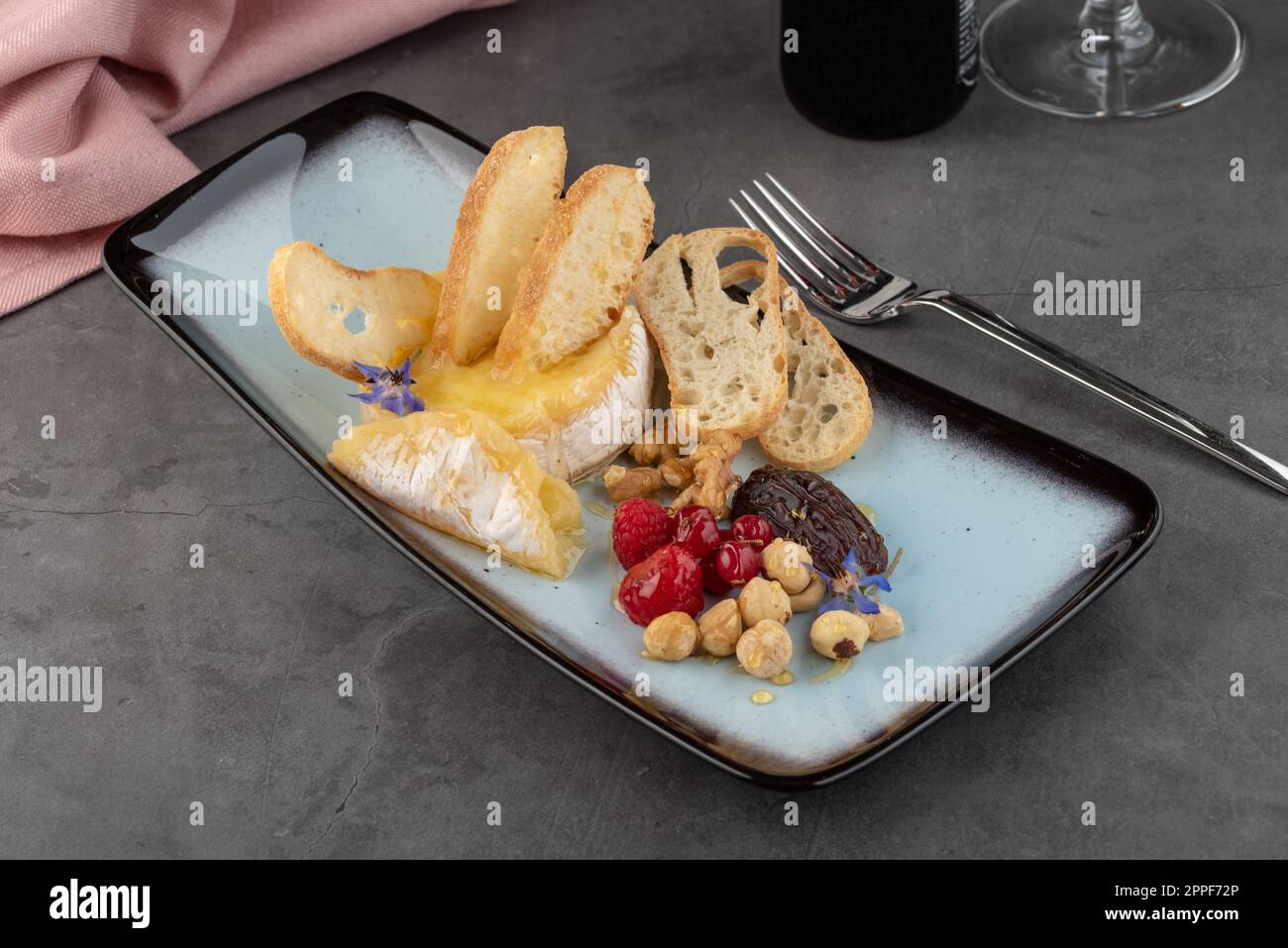 Formaggio di camembert caldo su tavola di pietra in raffinato ristorante Foto Stock