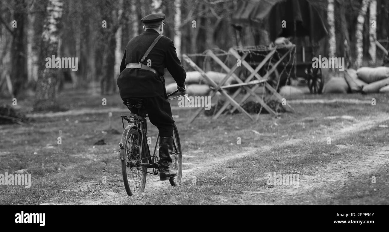 Re-enactor vestito come NKVD Forces cavalca Una bicicletta. Il Commissariato dei popoli per gli Affari interni, abbreviato in NKVD, era ministero degli interni dell'Unione Sovietica Foto Stock