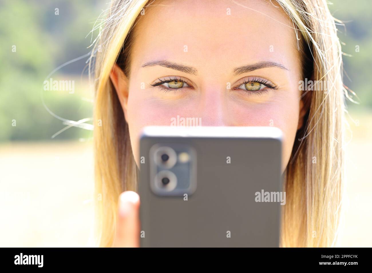 Vista frontale poftrait di una donna felice con gli occhi di bellezza che controllano il telefono Foto Stock