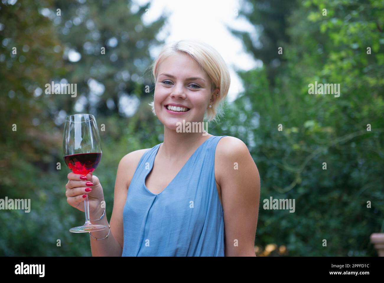 Giovane donna che ama il vino rosso al picnic, in Baviera, in Germania Foto Stock