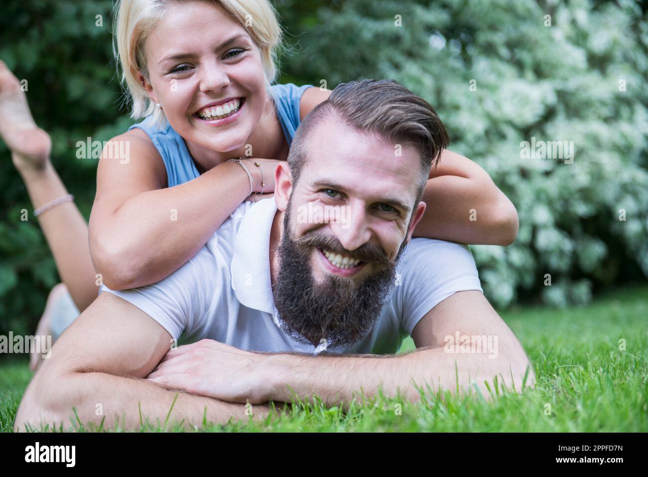 Ritratto di una giovane coppia felice sdraiata in giardino, Baviera, Germania Foto Stock