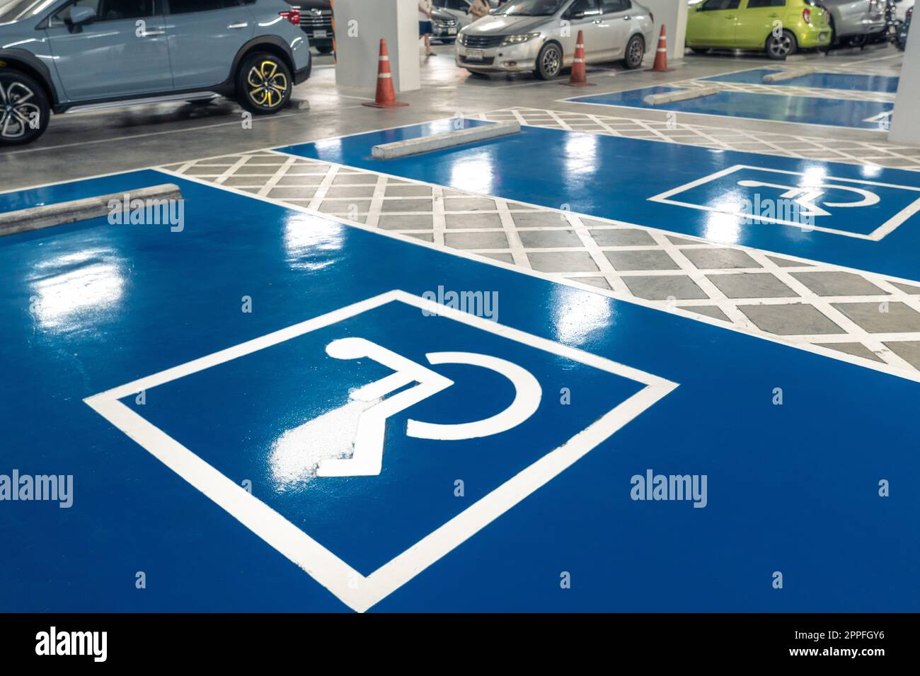 Parcheggio per auto riservato agli autisti disabili nel supermercato o nel centro commerciale. Parcheggio per disabili. Vernice segnaletica per sedie a rotelle sull'area parcheggio. Parcheggio per disabili blu e bianco. Foto Stock