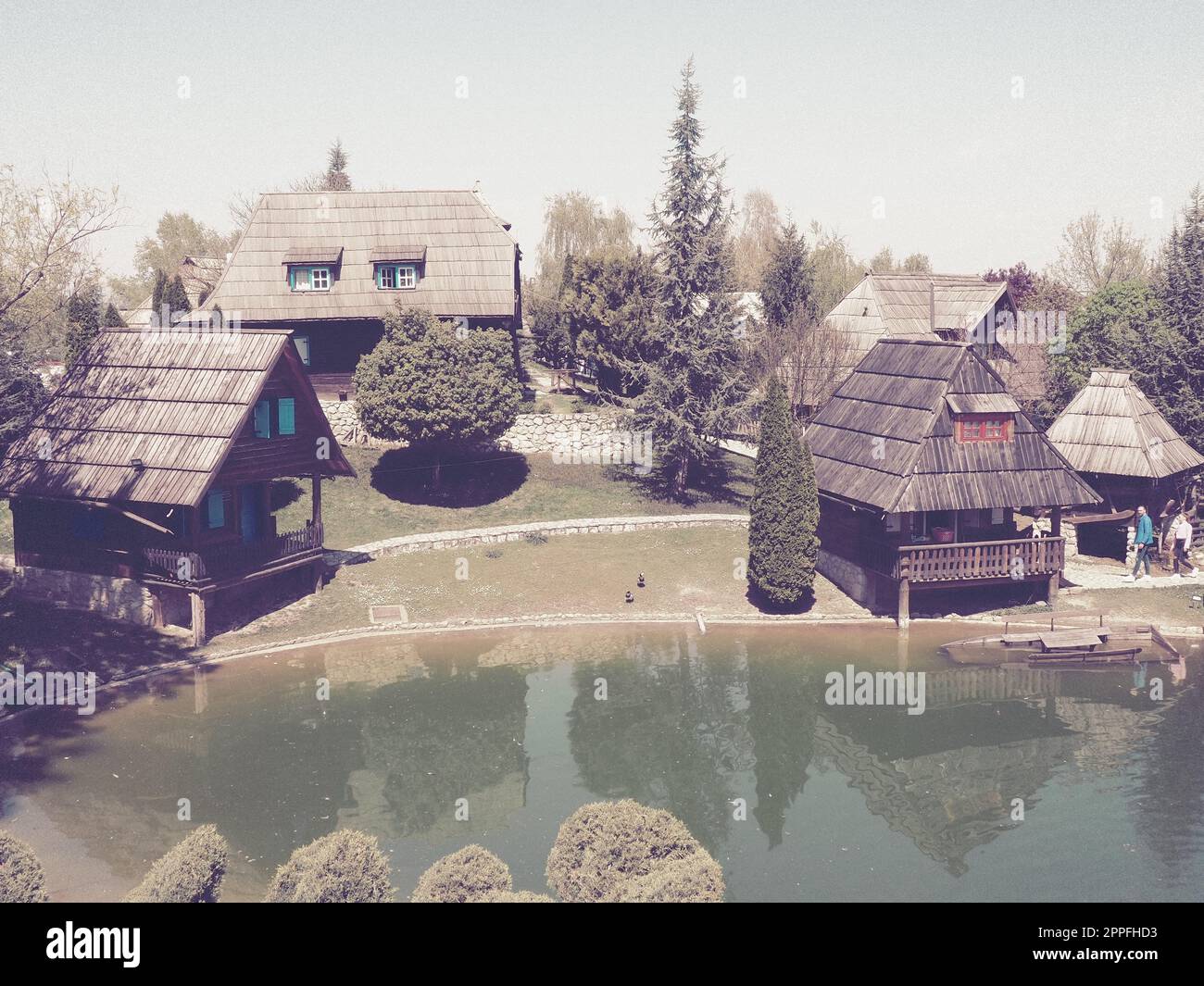 Stanisici, Bijelina, Bosnia ed Erzegovina. 25 aprile 2021 Ethno-Village, tradizionali case di villaggio fatte di tronchi, stile bosniaco di costruzione negli altopiani. Lago con acqua. Architettura in legno. Foto Stock