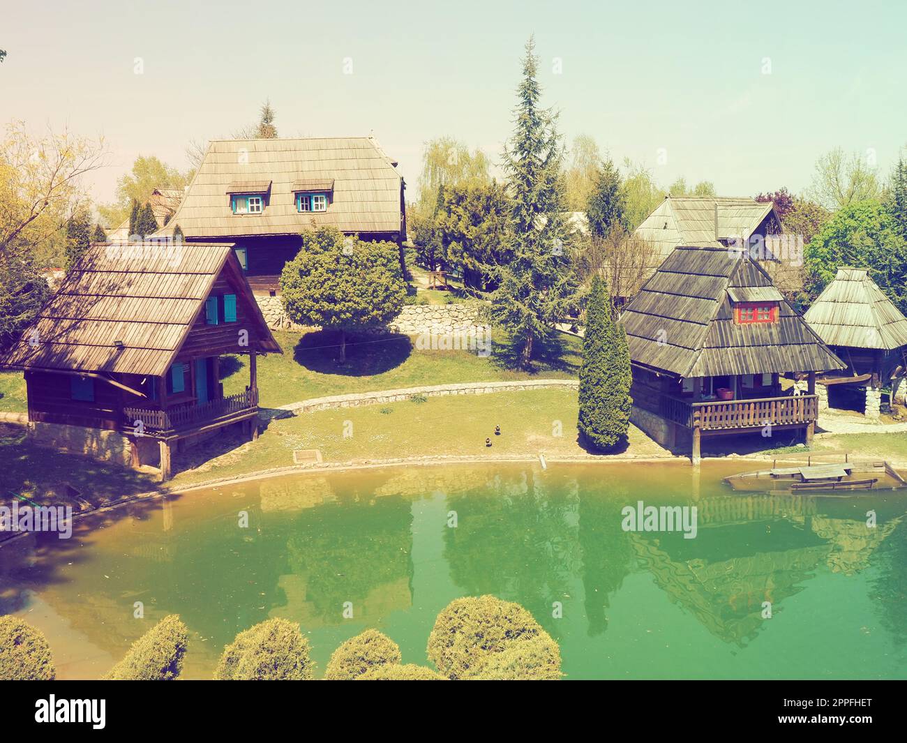 Stanisici, Bijelina, Bosnia ed Erzegovina. 25 aprile 2021 Ethno-Village, tradizionali case di villaggio fatte di tronchi, stile bosniaco di costruzione negli altopiani. Lago con acqua. Architettura in legno. Foto Stock