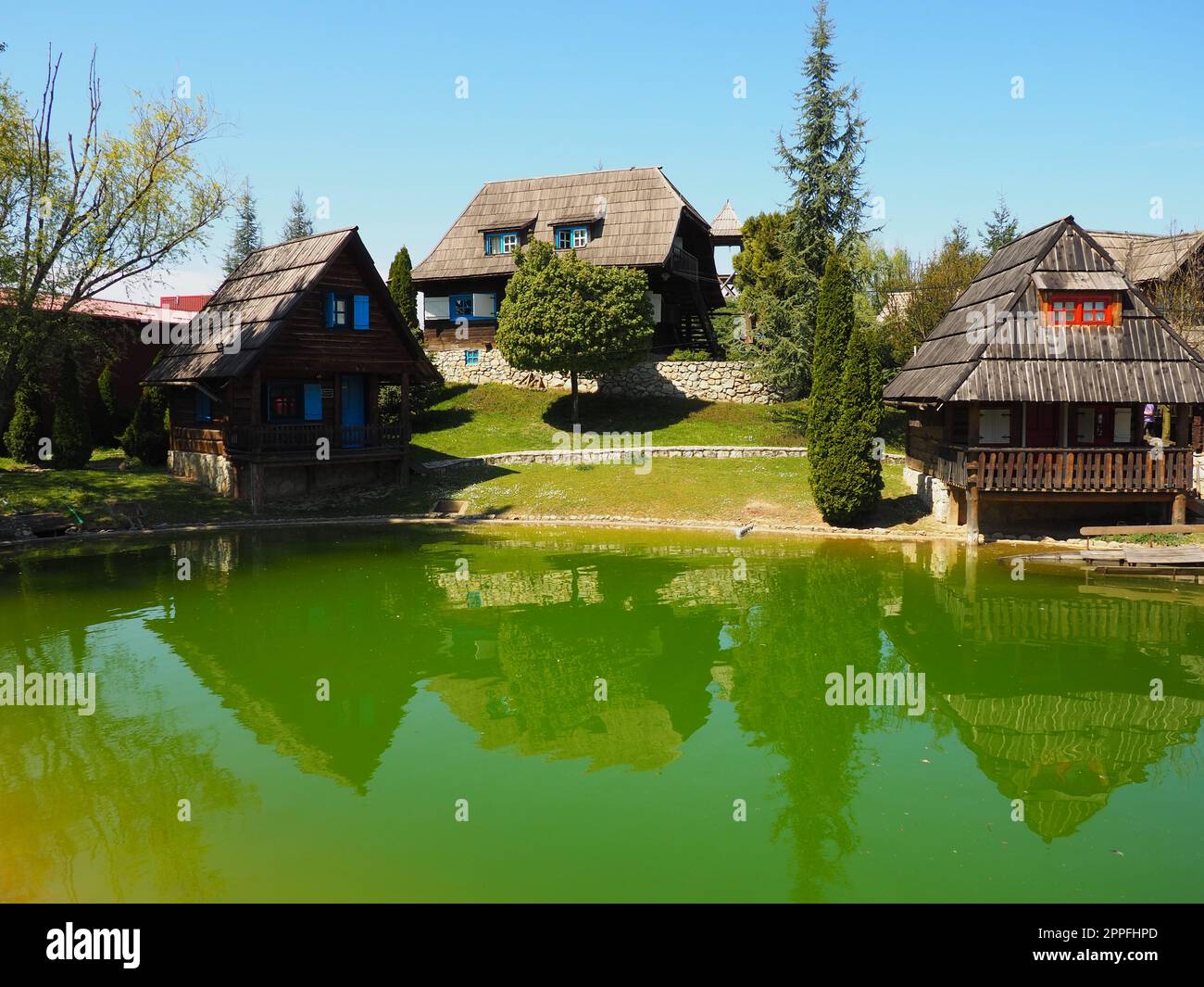 Stanisici, Bijelina, Bosnia ed Erzegovina. 25 aprile 2021 Ethno-Village, tradizionali case di villaggio fatte di tronchi, stile bosniaco di costruzione negli altopiani. Lago con acqua. Architettura in legno. Foto Stock