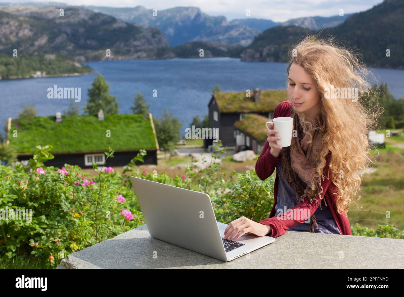 Ragazza freelance che lavora su un computer portatile in natura e paesaggi bellissimi Foto Stock