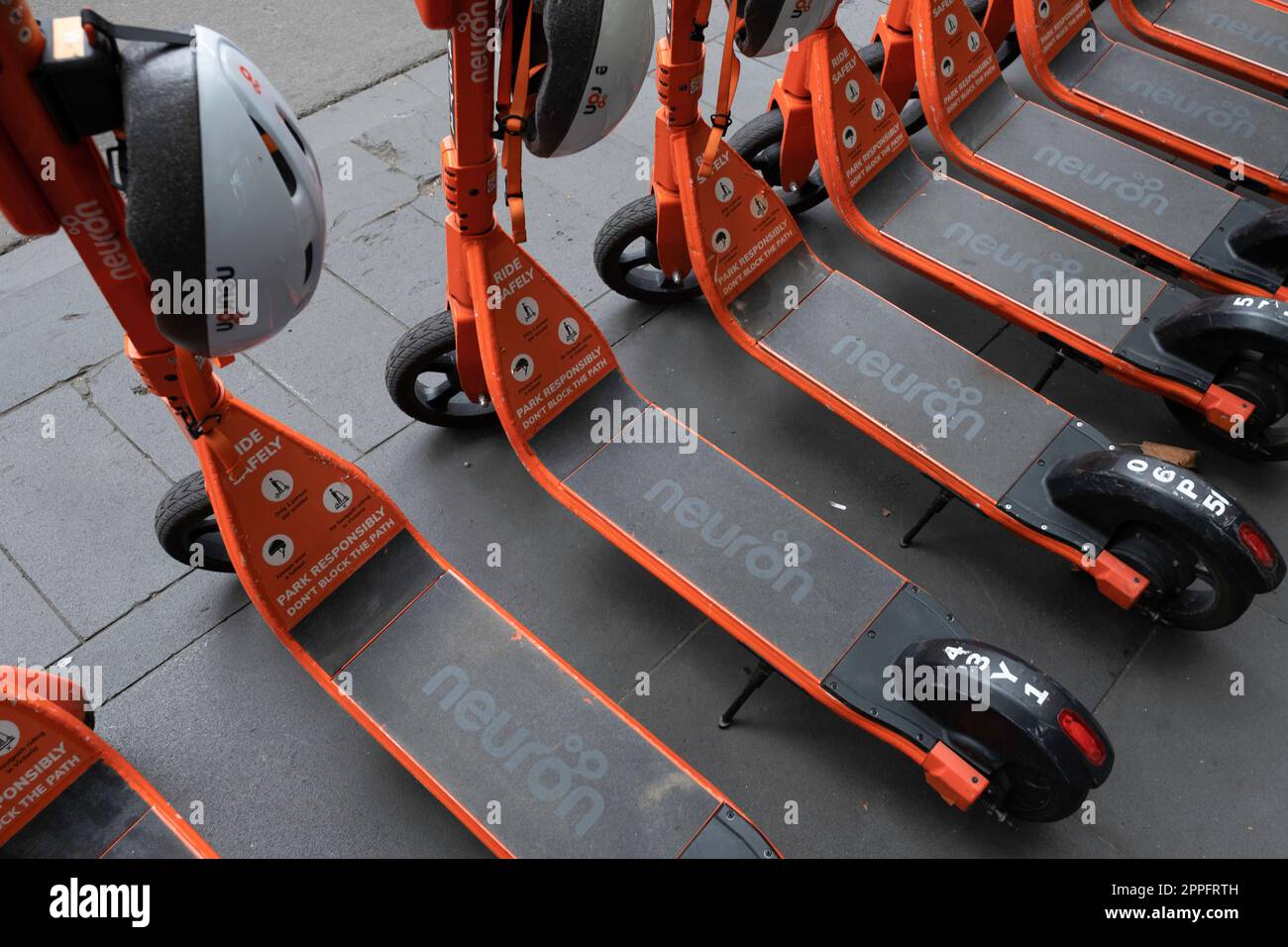 Fila di scooter elettrici condivisi o e-step con caschi in affitto sono in attesa di clienti in una strada a Melbourne, Victoria, Australia. E-mobil Foto Stock