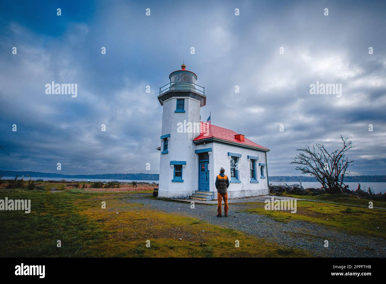 Un uomo si trova vicino a un faro storico sull'isola di Vashon Foto Stock