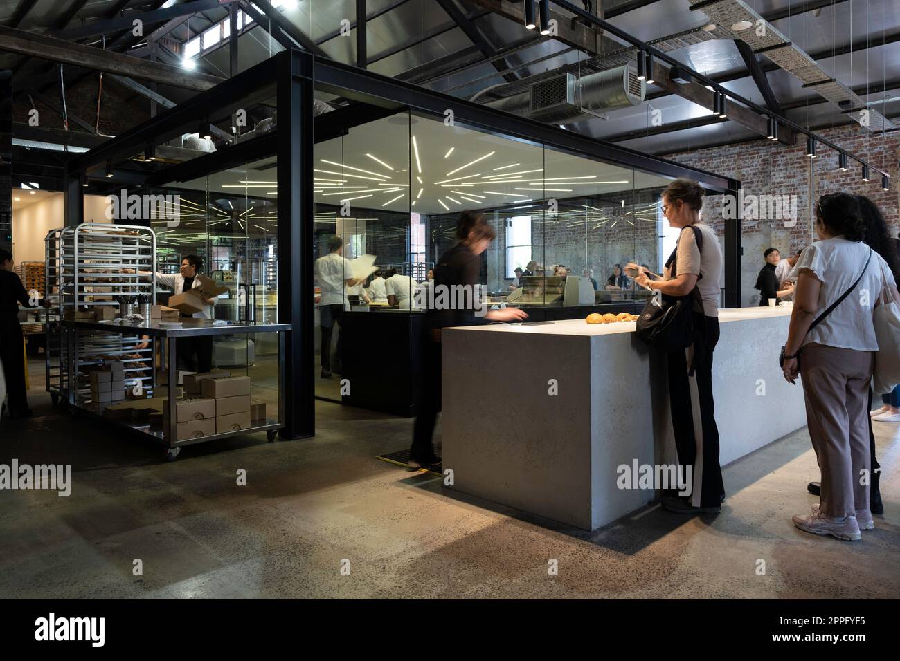 I clienti della famosa Lune Croissanterie a Melbourne Fitzroy coda all'interno per effettuare un ordine. Sullo sfondo, gli chef preparano croissant Foto Stock