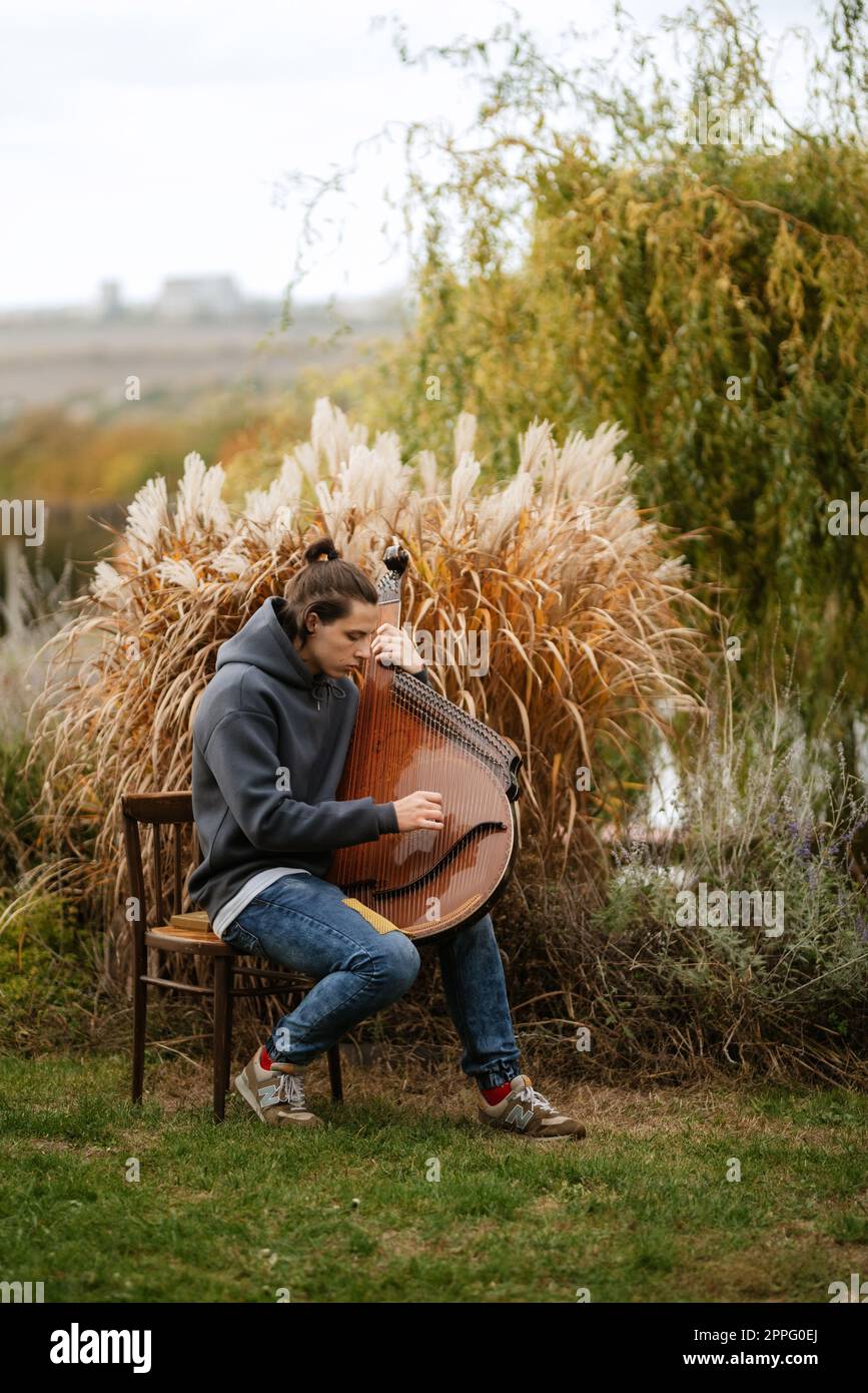 il giocatore bandura gioca in giardino Foto Stock