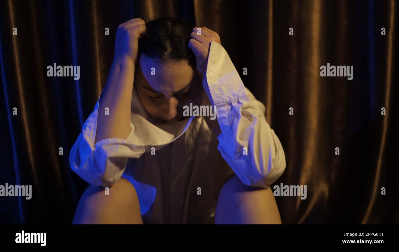 Bella giovane donna caucasica urlando fuori dalla rabbia direttamente nella fotocamera. Ragazza in Agony che rilascia le sue emozioni mentre è in lacrime. Ragazza triste con ansia. Concetto di abuso e violazione Foto Stock