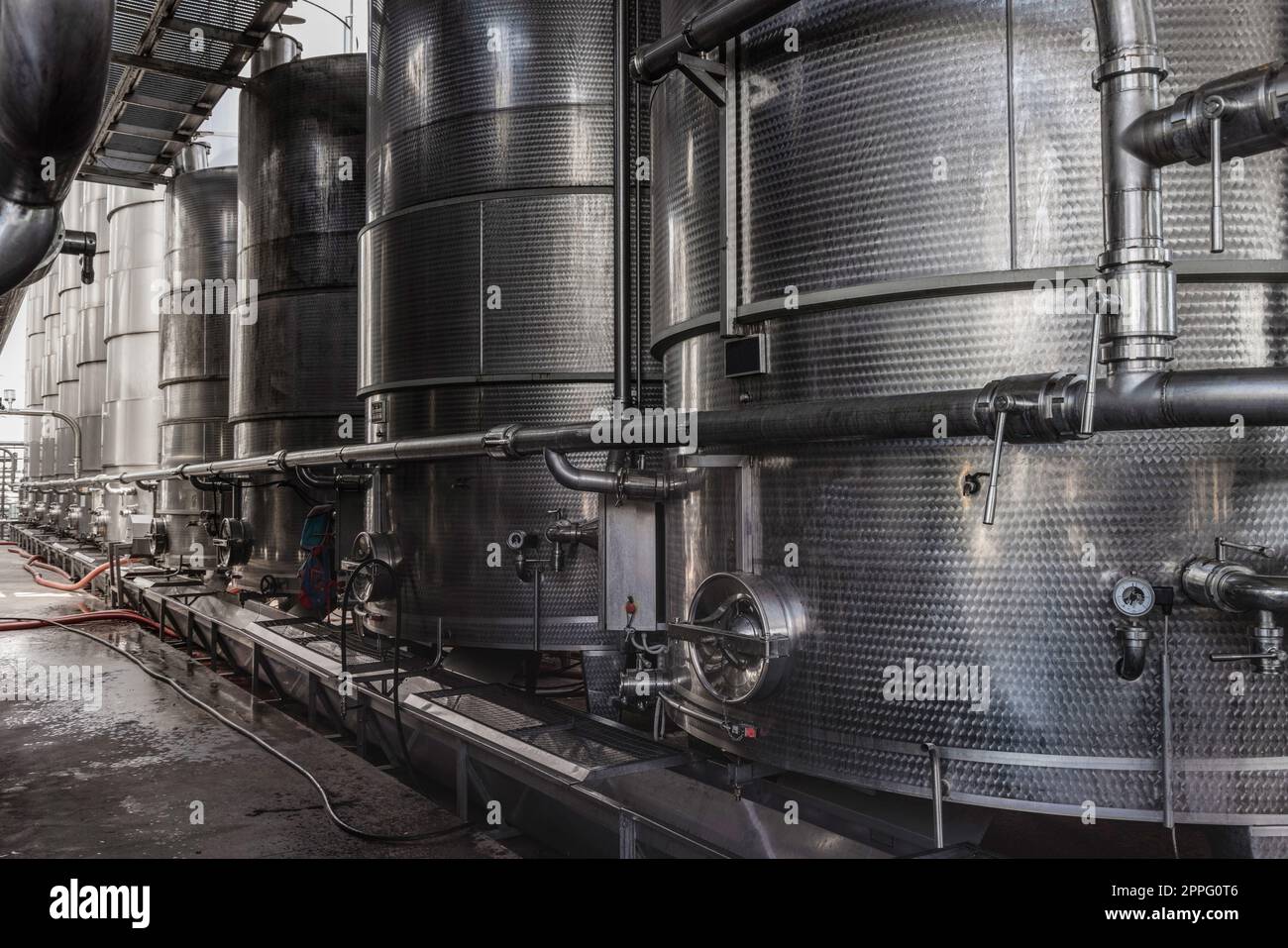 Vasche d'acciaio per la fermentazione del vino in una moderna cantina. Grandi silos di birreria per orzo o birra Foto Stock