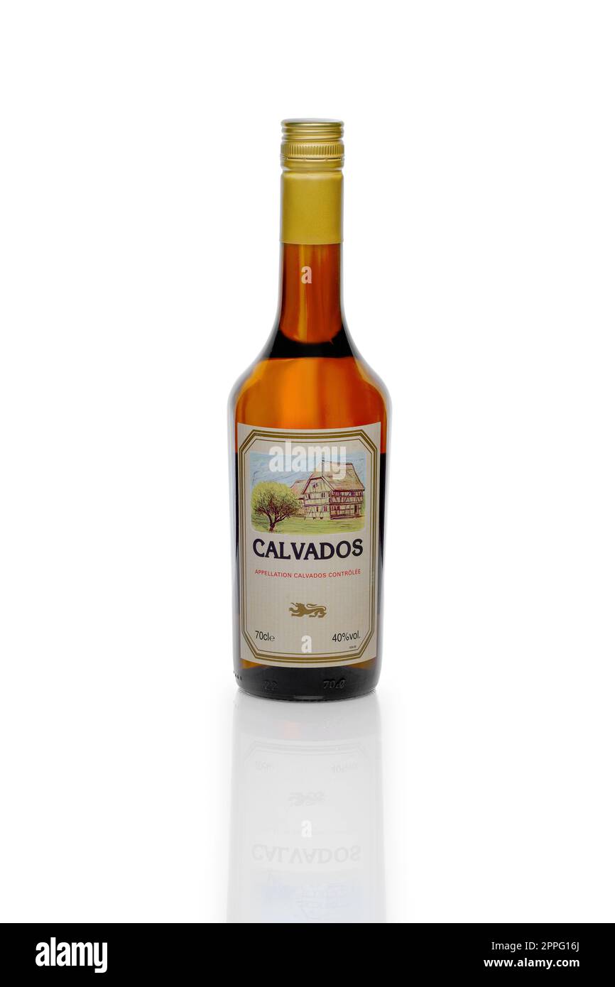 MINSK, BIELORUSSIA - 6 marzo 2017: Bottiglia di Calvados, brandy francese di mela con riflesso su tavolo di vetro isolato su sfondo bianco. Foto Stock